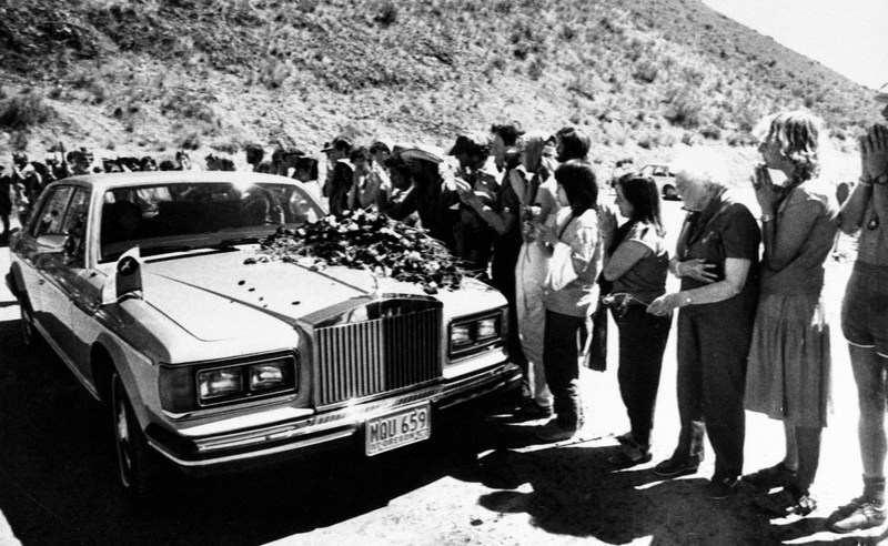 Bhagwan Shree Rajneesh drives his Rolls Royce as cult members throw flowers on his car in July of 1984 (AP Photo/Bill Miller)